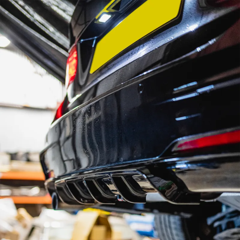 Aftermarket rear diffuser fitted to a dark blue car