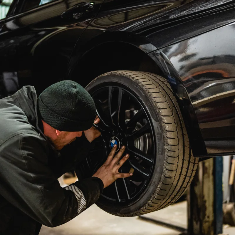 Technician refurbishing an alloy wheel on a BMW